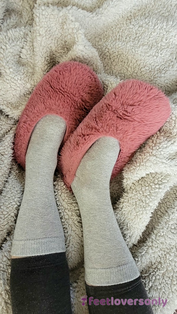 Rubbing Feet In Pink, Fluffy Slippers On Soft, Fluffy, White Blanket